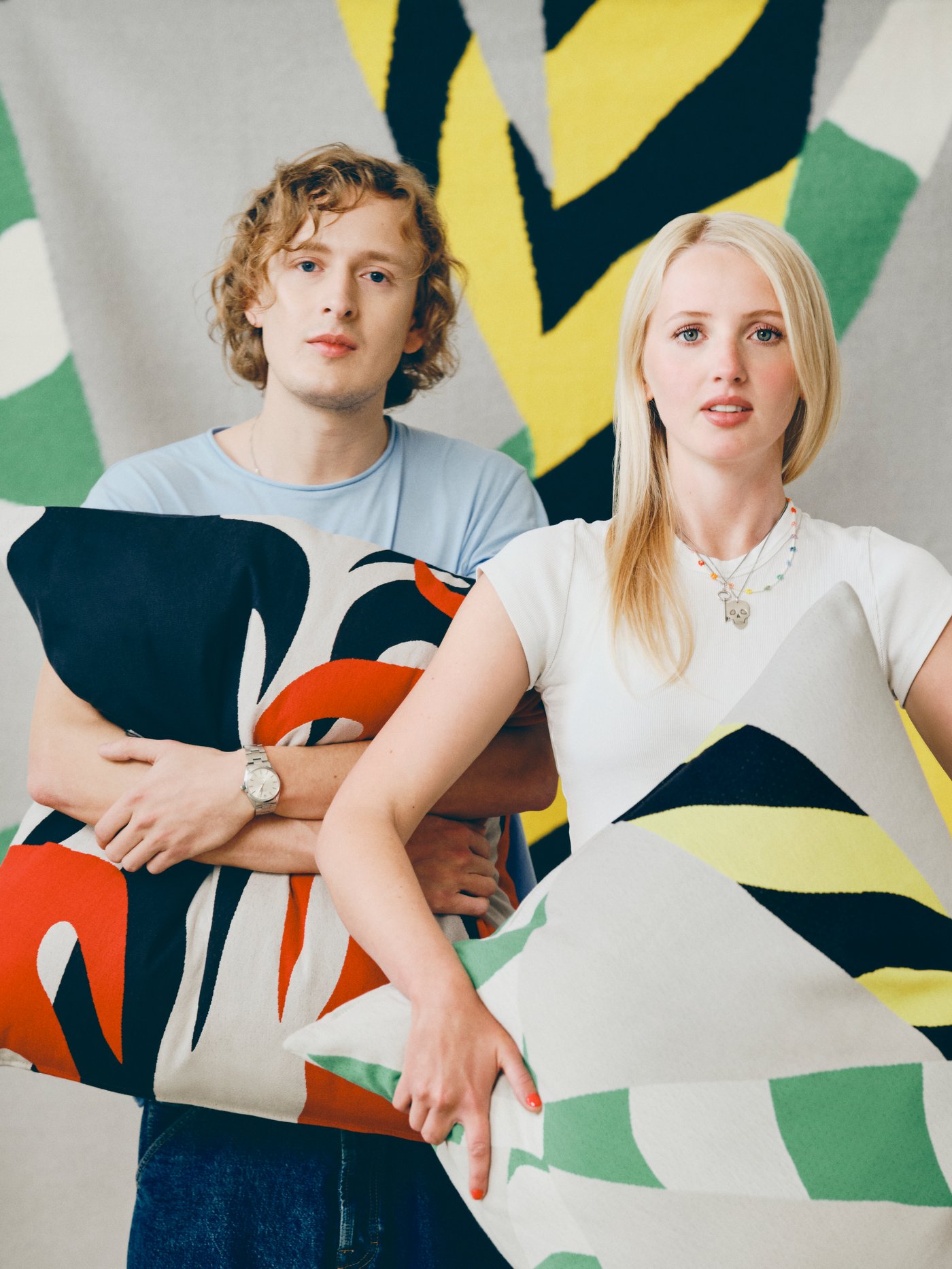 Designers Igor and Ingrid holding colourful cushions designed for the IKEA KONSTRUNDA art collection.