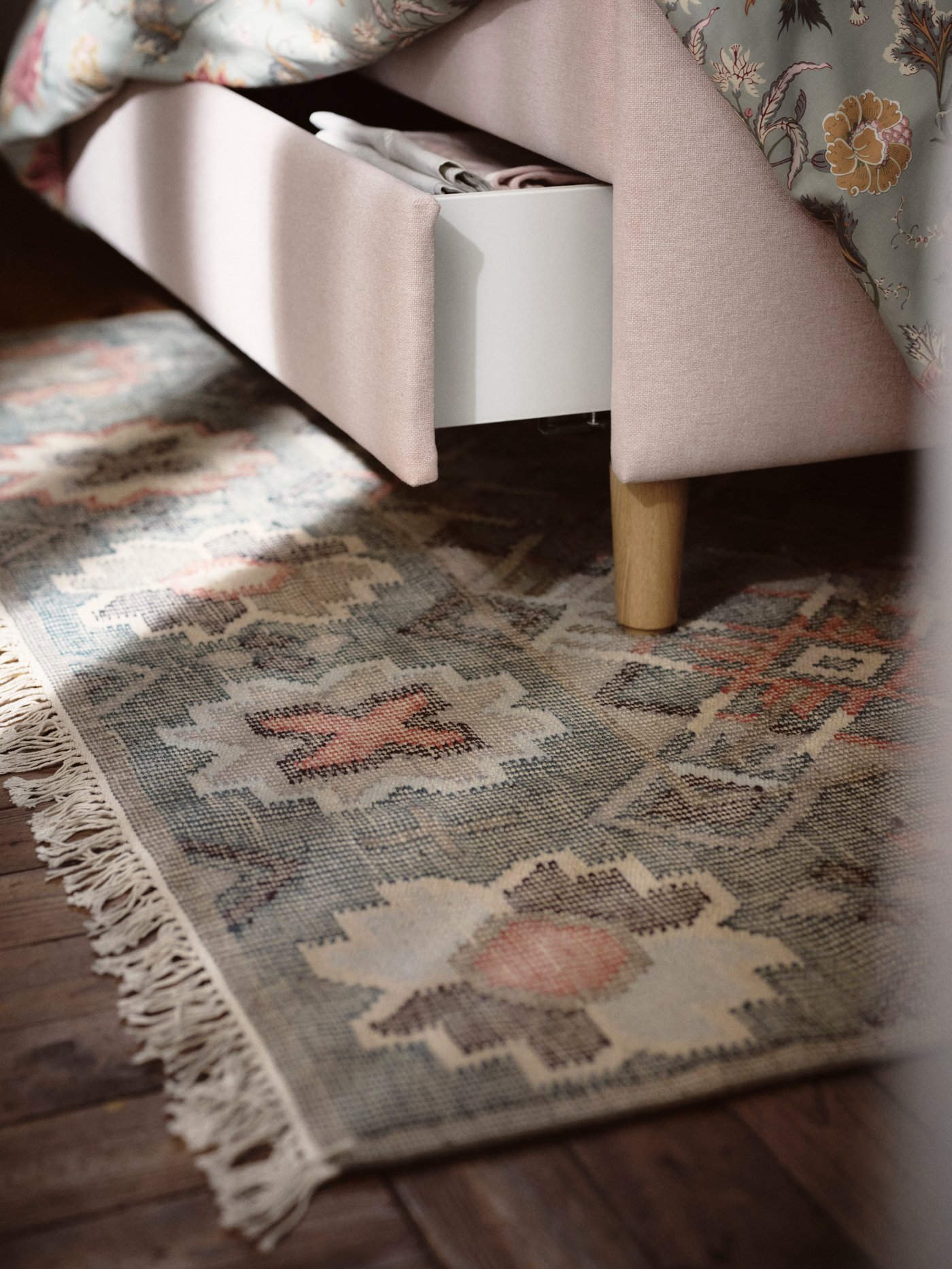 A handmade multicolour/diamond pattern VESTERVIG rug, flatwoven in the bedroom.