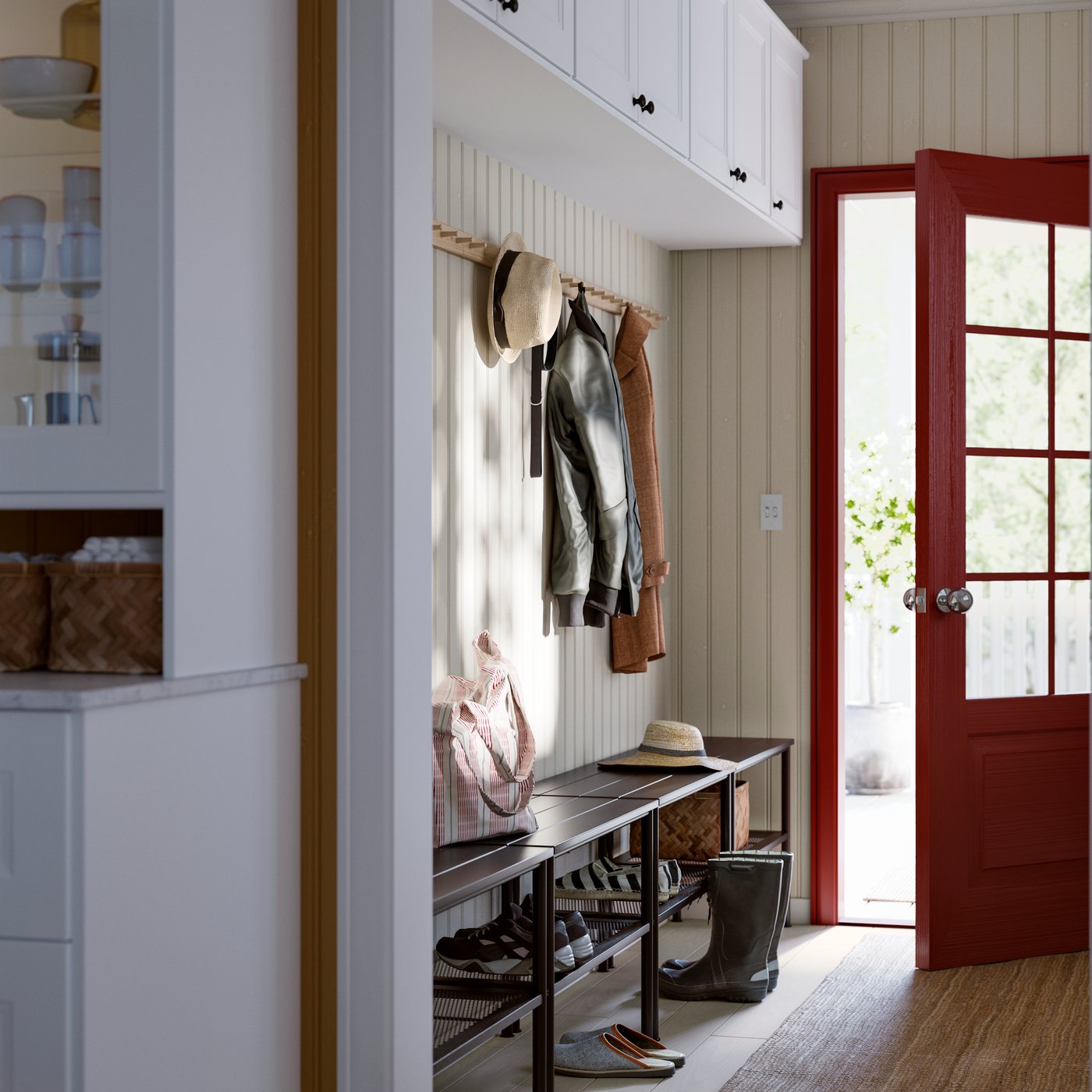 A mud room featuring a brown bench with hooks above for coats and a bright red door leading outside.