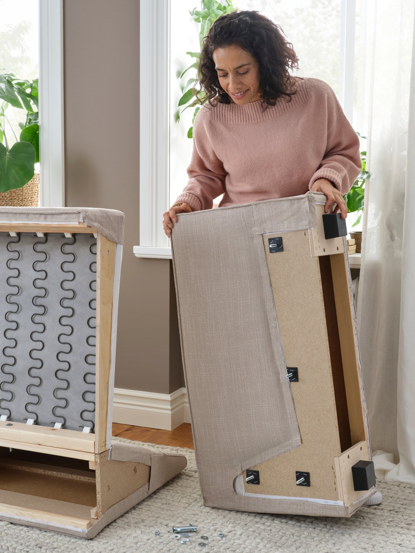 Женщина меняет чехол на диване