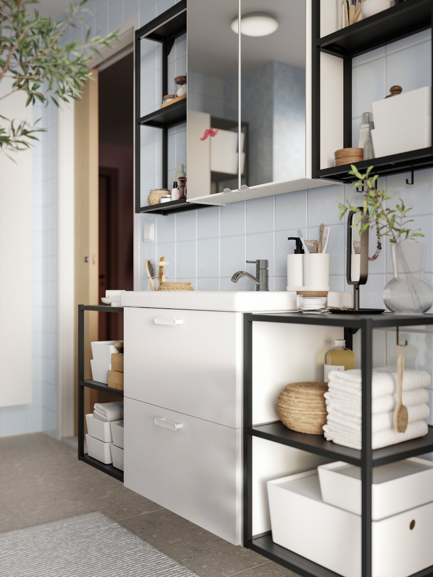 En badeværelsesvæg med et ENHET underskab til vask med to skuffer, åbne stel med hylder og to spejllåger.