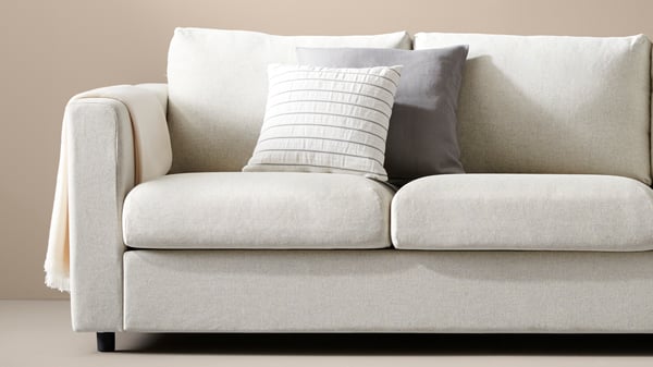 Ljus VIMLE soffa med mjuka dynor och ljusa kuddar i en neutral inredning.