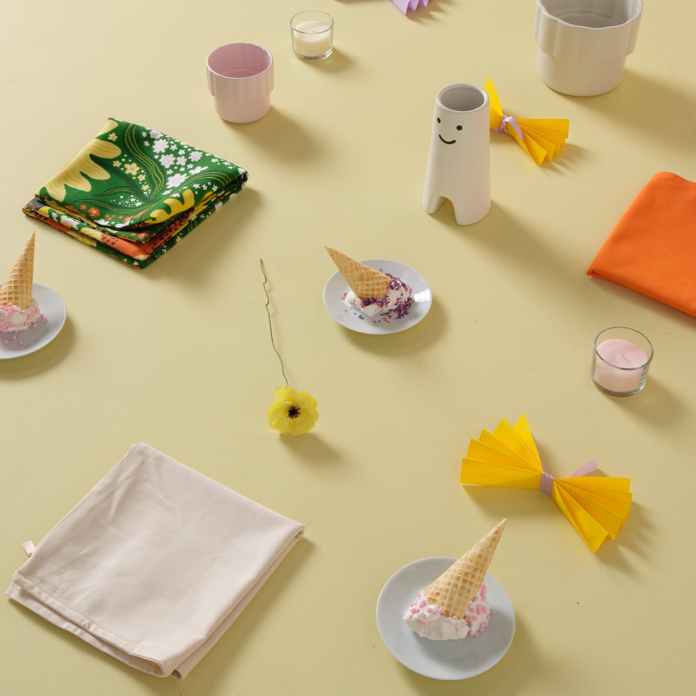 淡いイエローの面にFRÖVÄXT/フローヴェクスト 花瓶、HÄNGSÄLG/ヘングセルグ 鉢カバー、LOTSFÅGEL/ロッツフォーゲル アロマキャンドルがディスプレイされているムードボード。