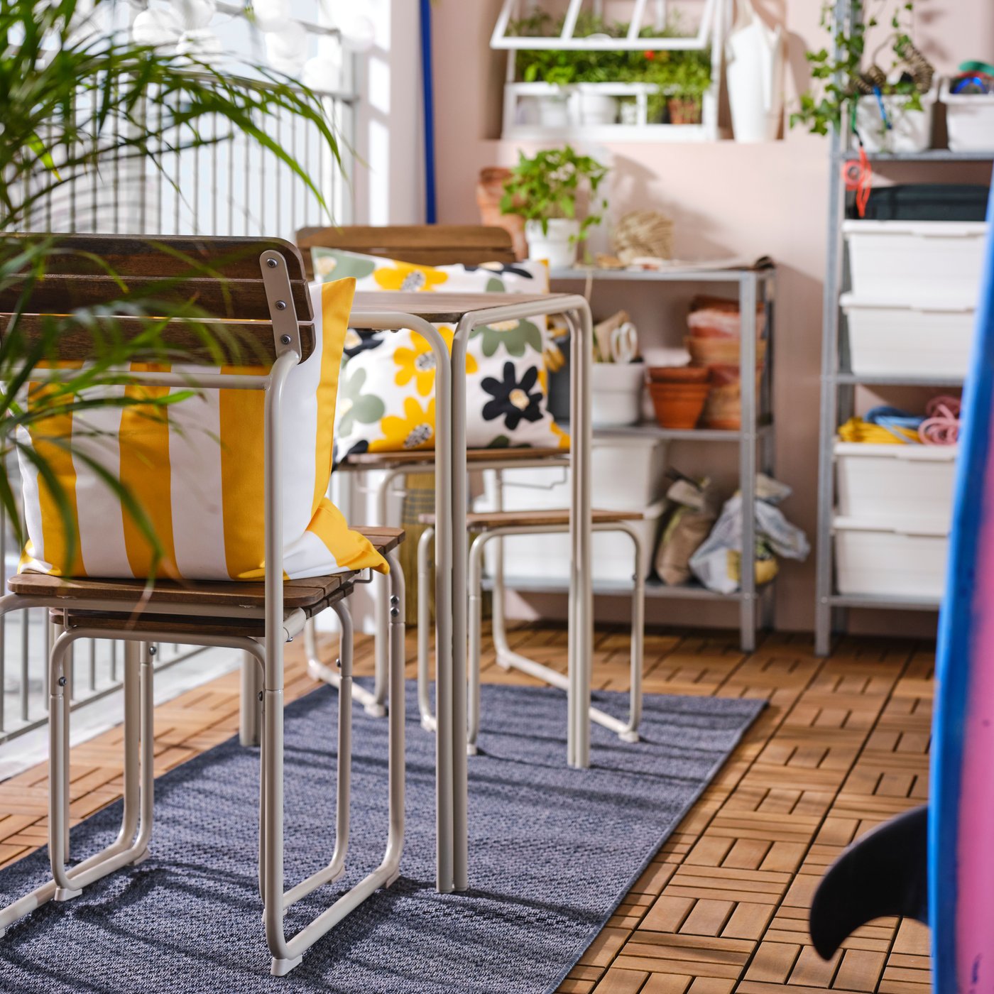 Un juego de balcón FURUÖN en un balcón con piso RUNNEN. Cada silla del juego tiene un cojín de terraza IKEA.