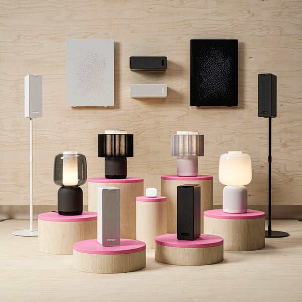 The SYMFONISK range with lamps and speakers arranged on wooden pedestals.