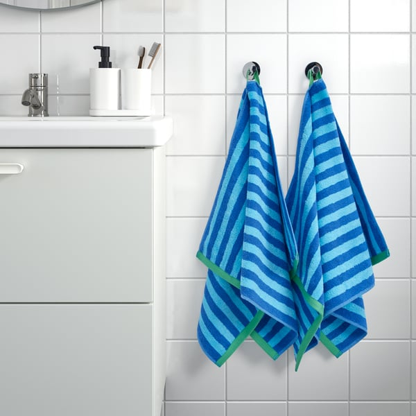 A bright blue/light blue striped SLÅNHÖSTMAL hand towel