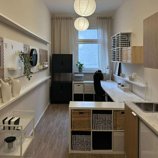 wyposazone biuro, obok okna czarnametalowa szafka