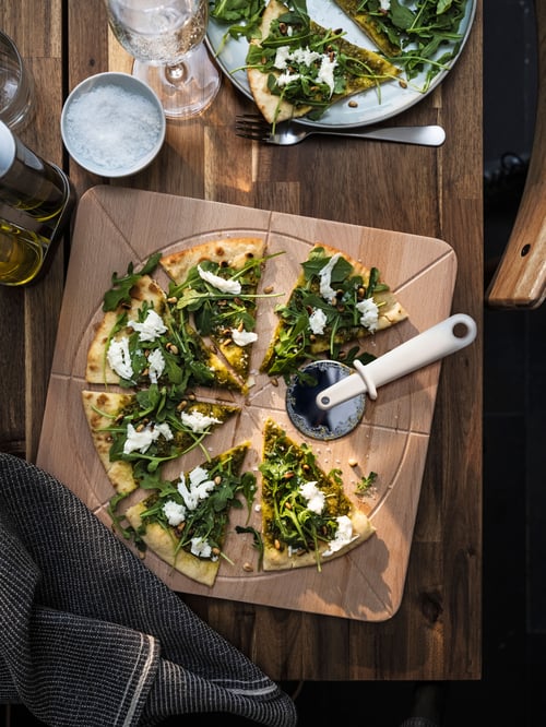 Outdoor featuring a beige SÅPÖRTMAL chopping board placed on a rectangular NACKANÄS table, next to a MARIATHERES tea towel.