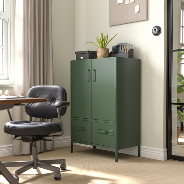 A dark green IDÅSEN cabinet with doors and drawers sits in an office.