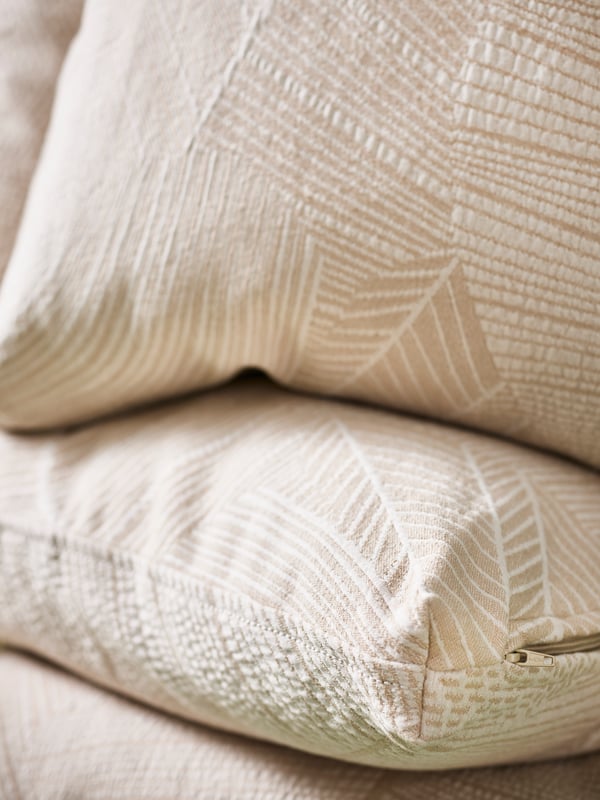 The pattern, texture and boxy corner of the JÄTTEGRAN cushion cover in off-white.