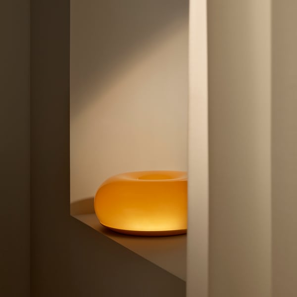 An orange glass/round VARMBLIXT LED table/wall lamp