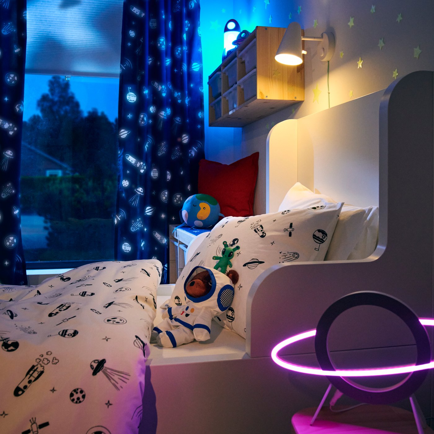 A rocket/multicolour AFTONSPARV LED table lamp in the childrens room