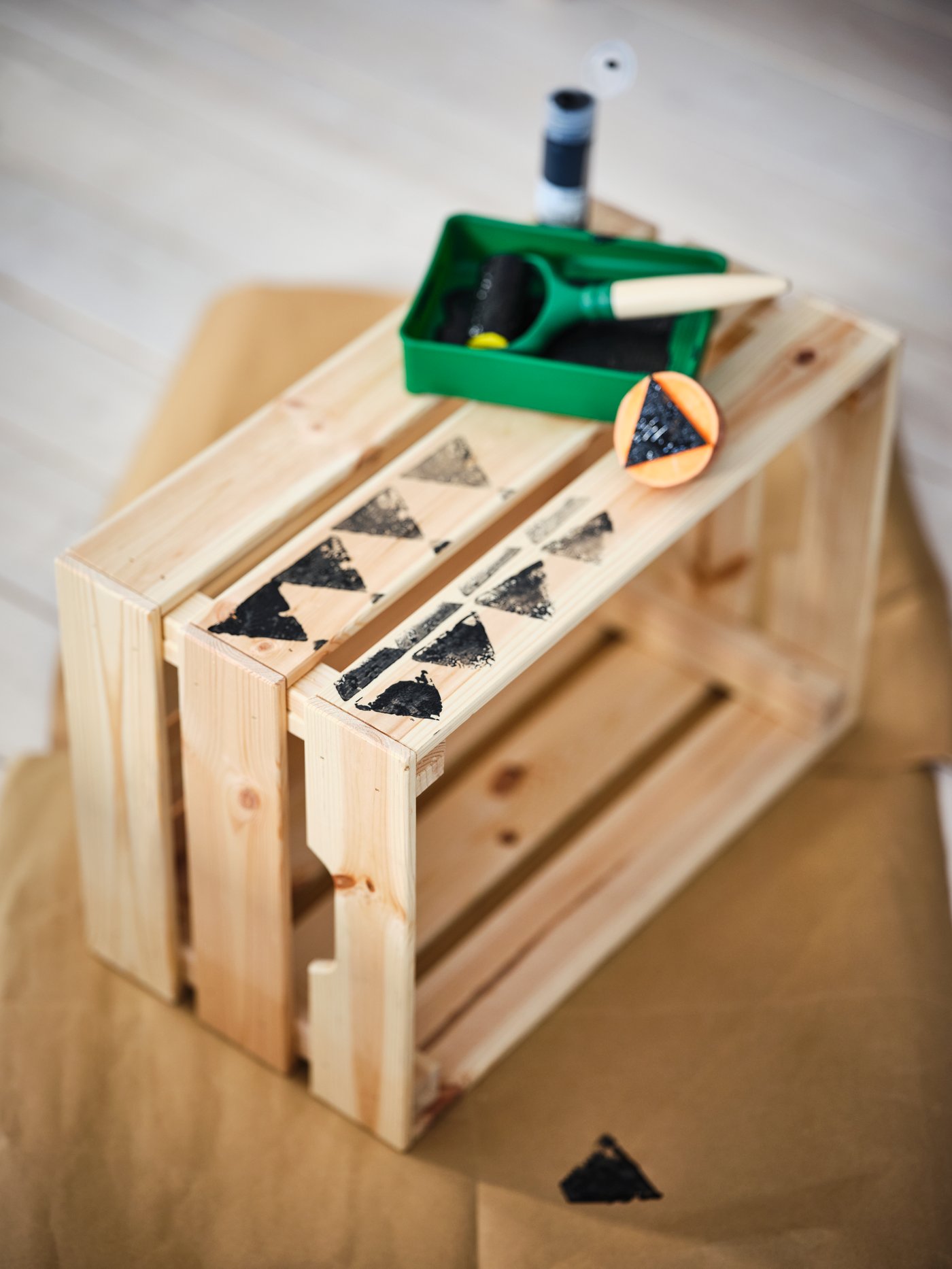 Selbst gestaltete IKEA Holzkiste mit schwarzem Stempelmuster und Bastelmaterialien – kreative DIY-Idee für Zuhause