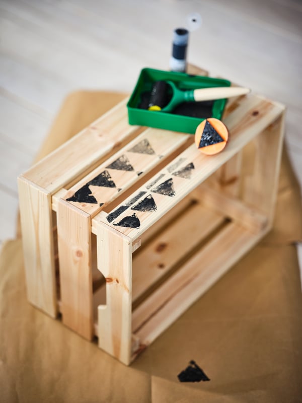Selbst gestaltete IKEA Holzkiste mit schwarzem Stempelmuster und Bastelmaterialien – kreative DIY-Idee für Zuhause

