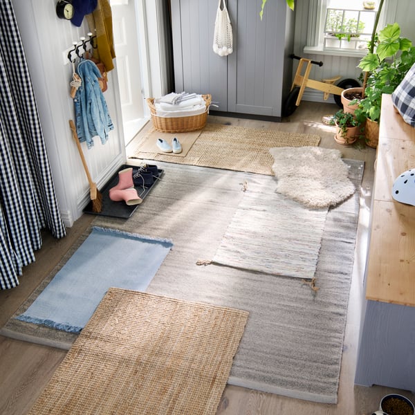 Ein großer Familienflur von oben gesehen, mit vielen kleineren Teppichen verschiedener Art auf dem Hauptteppich darunter.