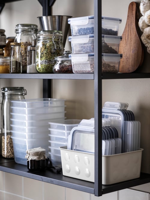 Stacked, tidily organised IKEA 365+ food containers and kitchen accessories in an anthracite ENHET wall frame with shelves.