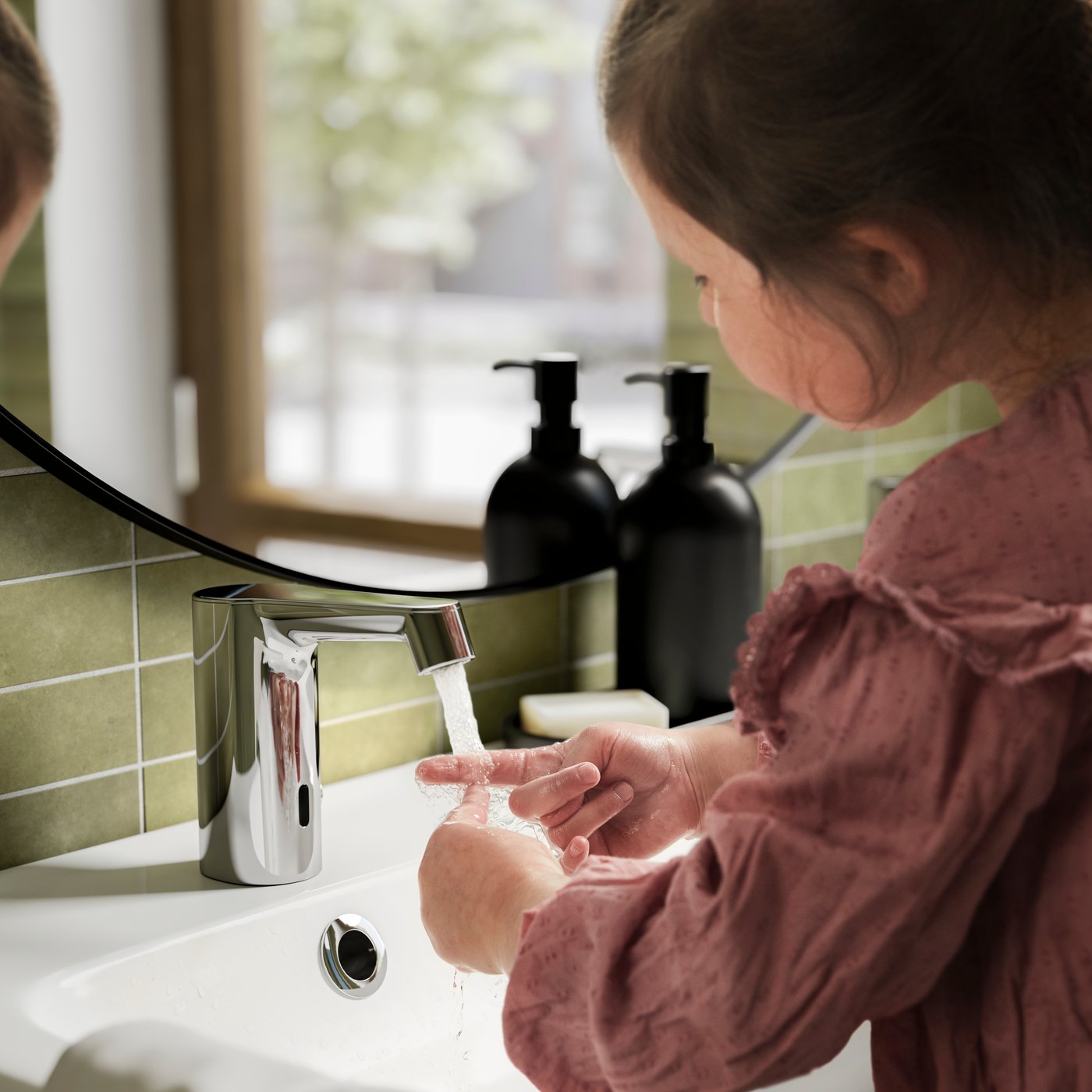 At an ODENSVIK double wash-basin, a person washes their hands under a BROGRUND wash-basin mixer tap with sensor.