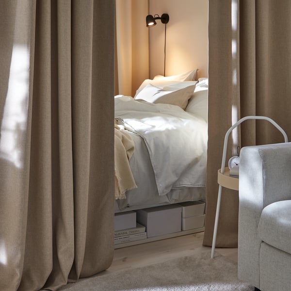 A black SKURUP wall lamp in the bedroom