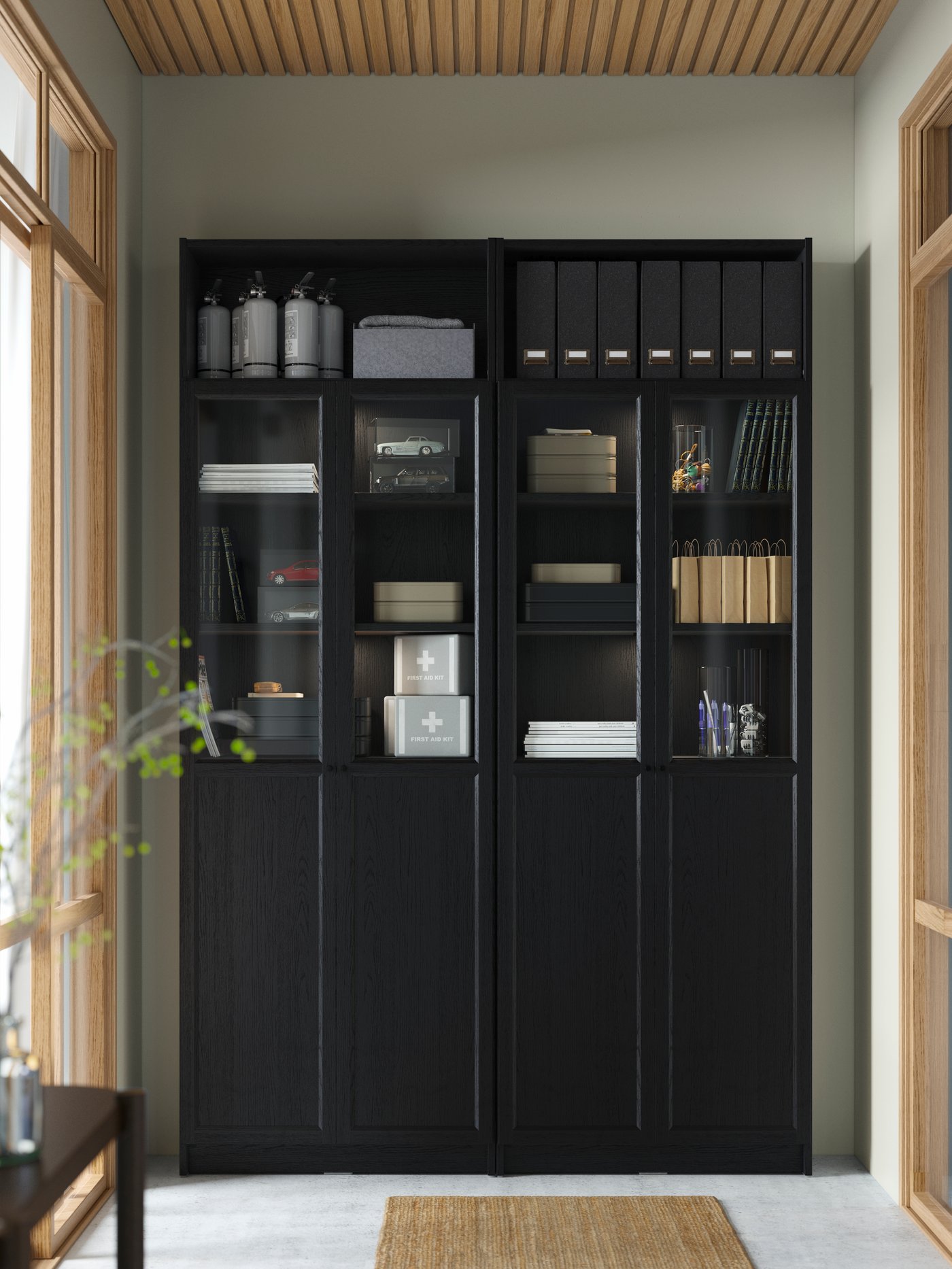 A large black BILLY bookcase combination with closed doors, glass doors and open shelves. A rug in natural fibre.
