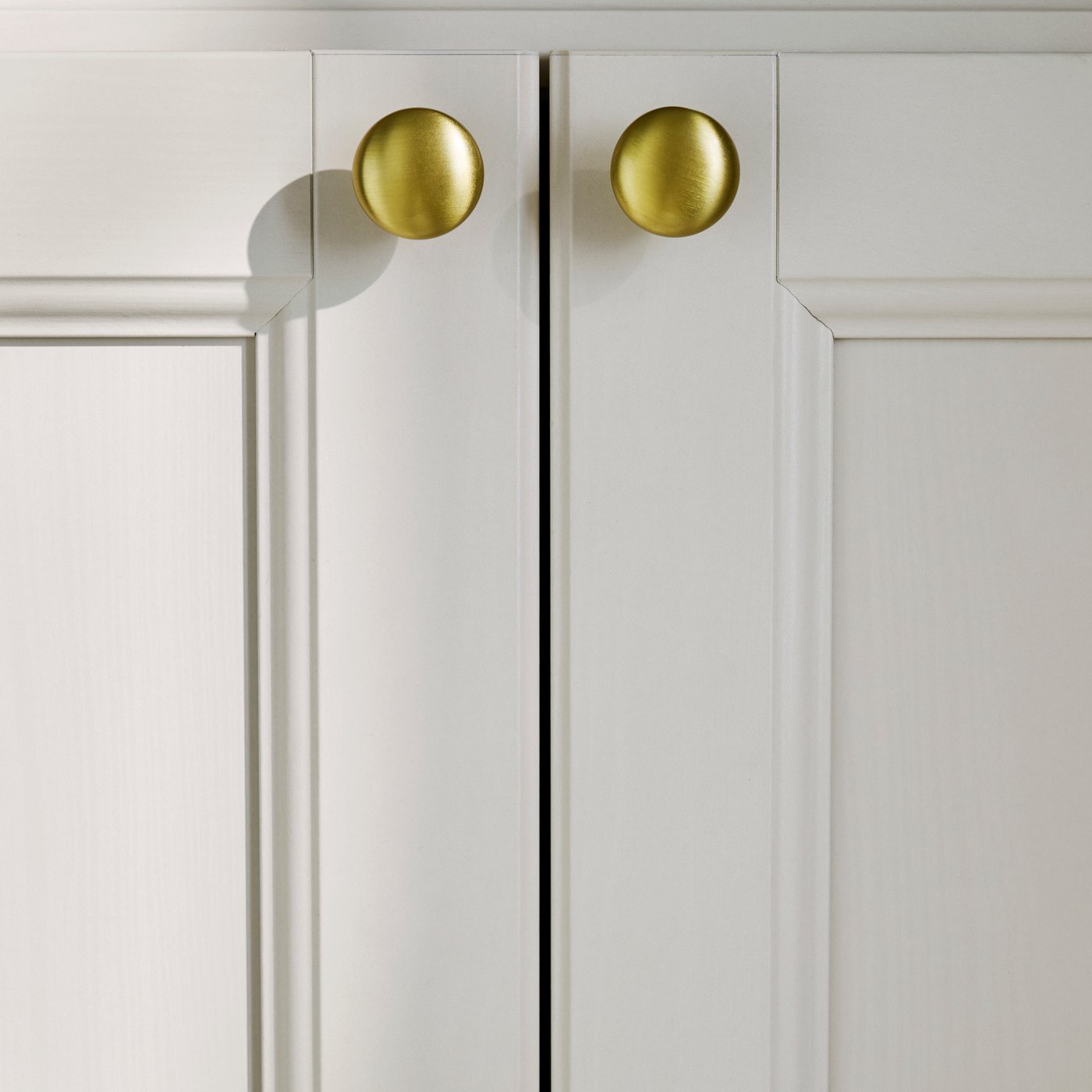 A close-up of the beige GULDDRAGARE storage combination featuring four doors and shelves, showcasing smooth handle details.