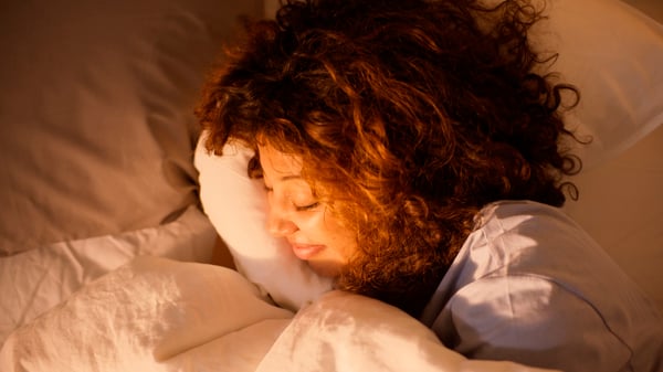 A woman sleeping with direct sunlight hitting her face