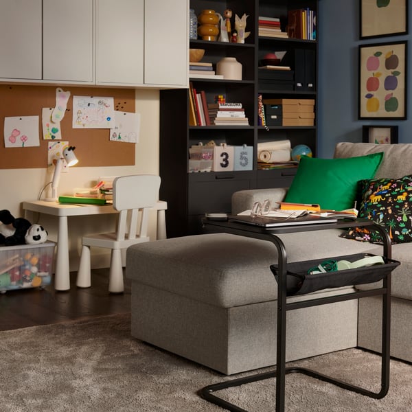 A beige/grey BÅRSLÖV 3-seat sofa-bed with chaise longue in a light living room, surrounded by a children’s play area.