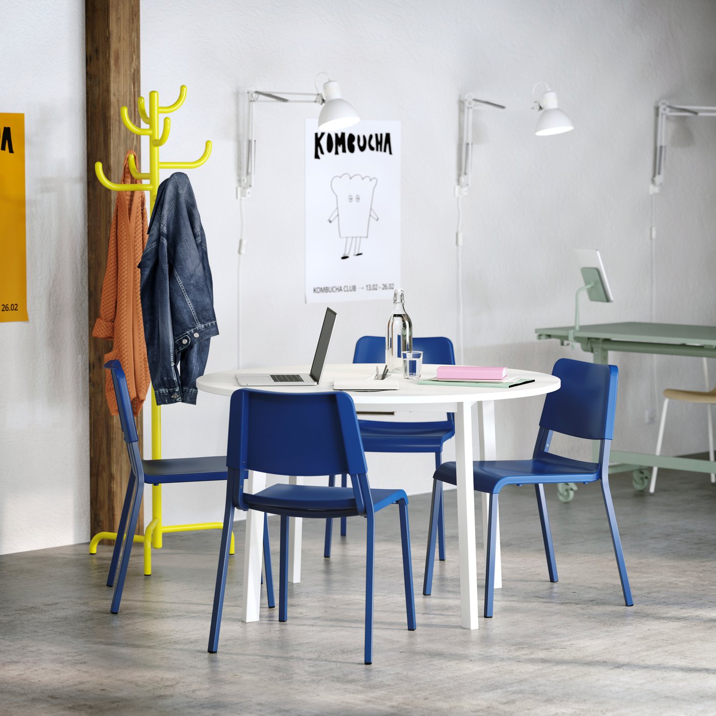 A white MITTZON conference table with four blue TEODORES chairs. A yellow steel hat and coat stand stands by the wall.