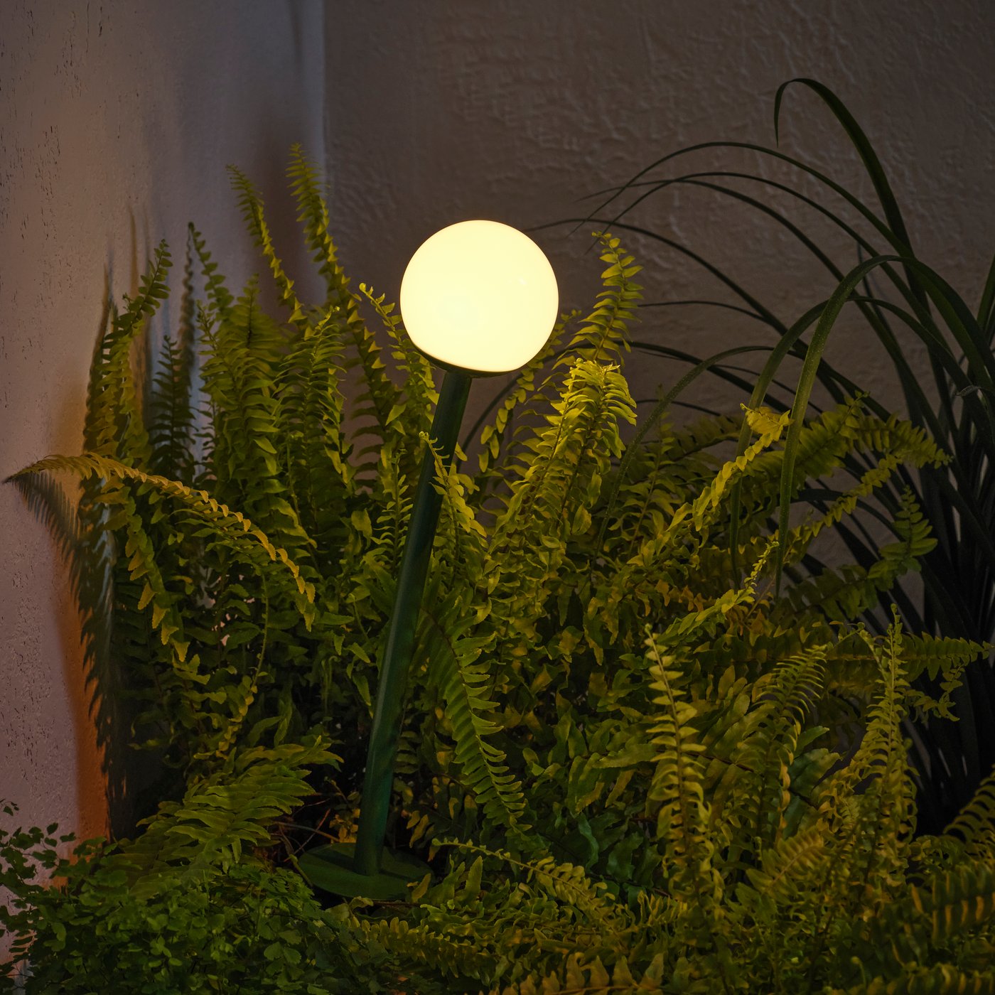 An outdoor dark green SOLVINDEN LED solar-powered ground stick.