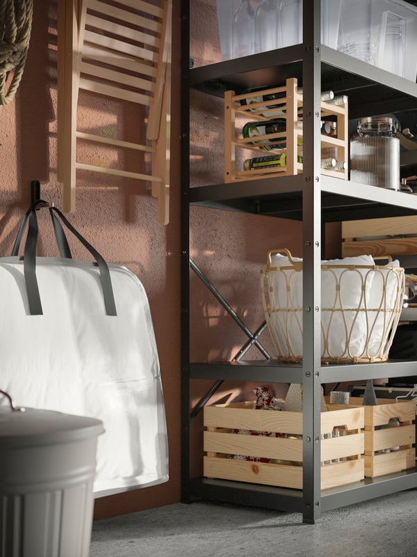 Part of a garage where secondary-storage items are neatly arranged hanging on the wall, in boxes and in BROR shelving units.