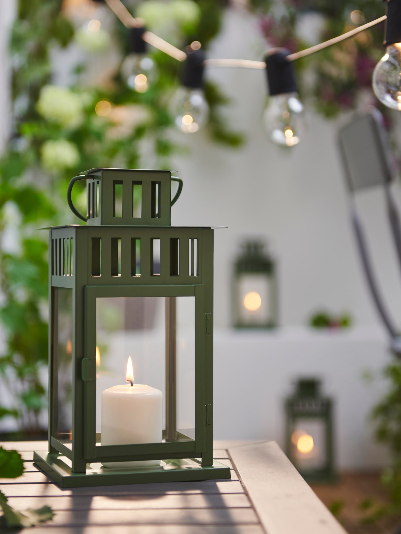 A green BORRBY lantern for pillar candle, in/out