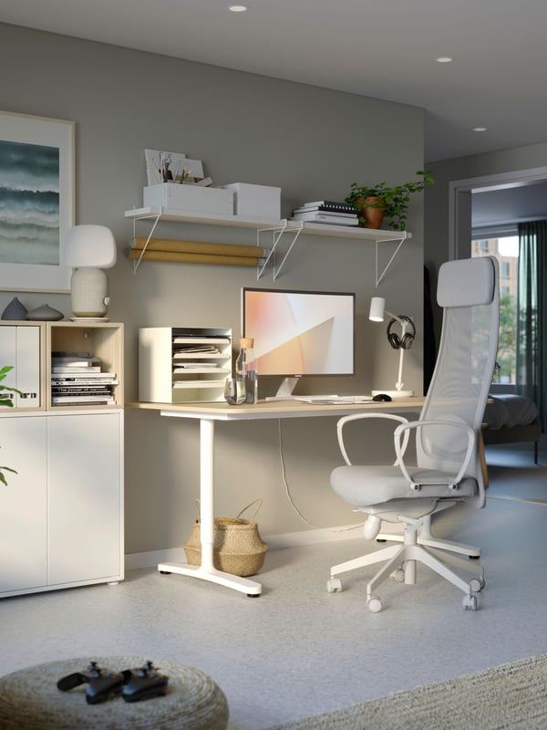 Silla de escritorio gris con blanca MARKUS junto a escritorio BEKANT con altura regulable
