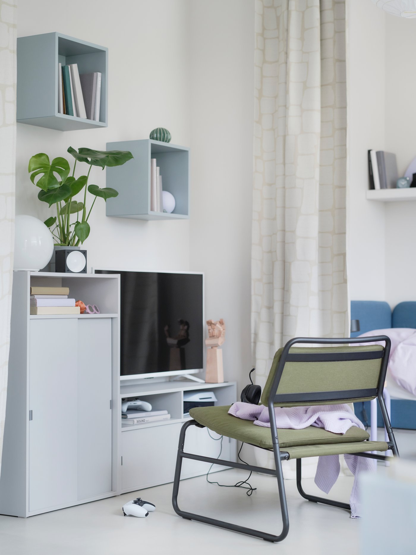A flexible zone for gaming with SPIKSMED TV bench and cabinet  in light grey and an olive-green LINNEBÄCK easy chair.