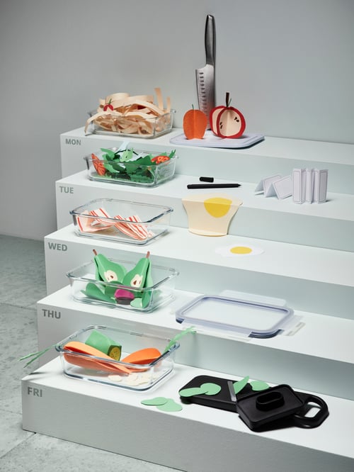 Sur un podium où sont indiqués les jours de la semaine, des contenants IKEA 365+ en verre avec des reproductions d'aliments en tissu.