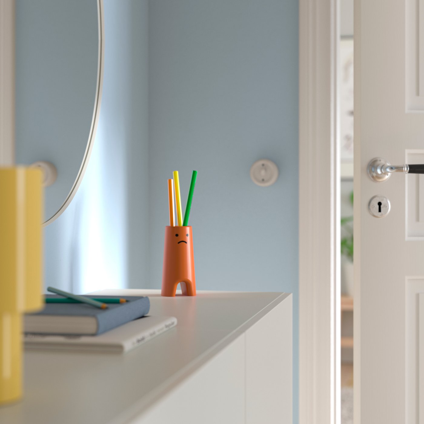 مزهرية FRÖVÄXT بنية برتقالية اللون عليها وجه مبتسم.