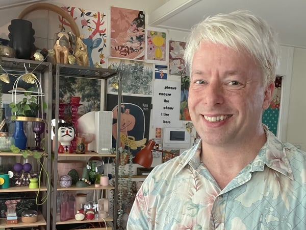 Anton posing with collections displayed behind him on a shelf.