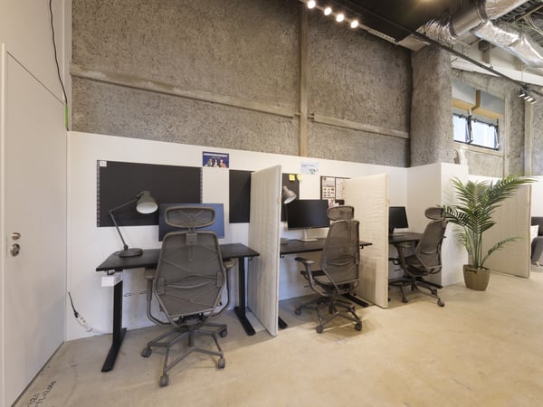 仕切り付きのワークステーションが並ぶオフィス。観葉植物が彩る、快適な作業環境