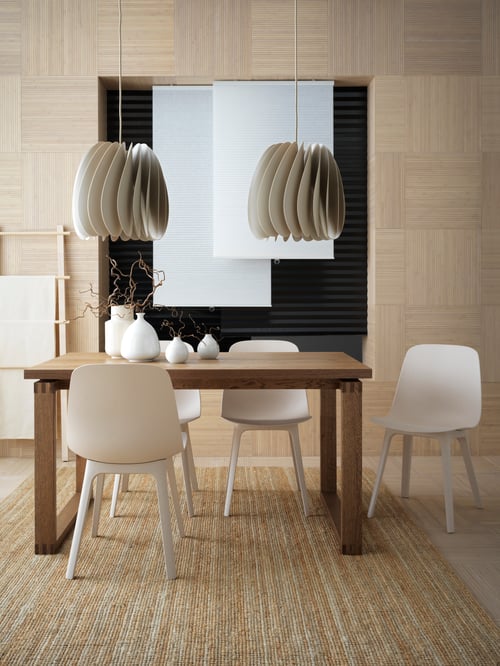 Dining area with brown dining table, four chairs, pendant lamps, cellular blinds, vases, block-out pleated blinds and a rug.