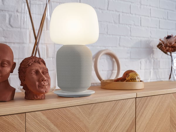 Panneau supérieur BESTÅ en placage de chêne dans le salon. Lampe posé sur le meuble à côté de statues. 