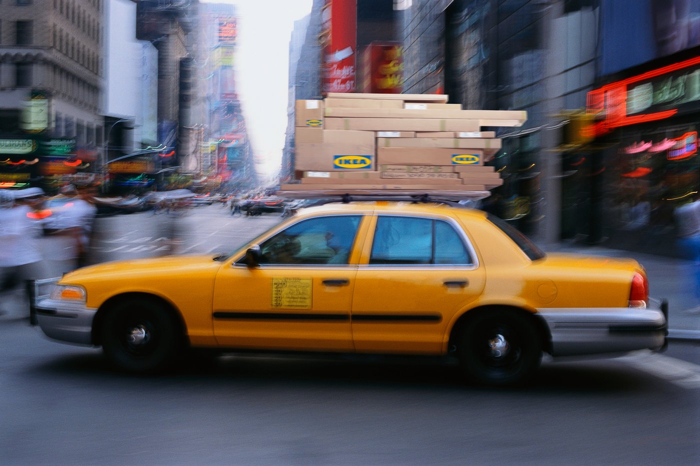 מכונית צהובה ועל הגגון שלה יש חבילות של איקאה