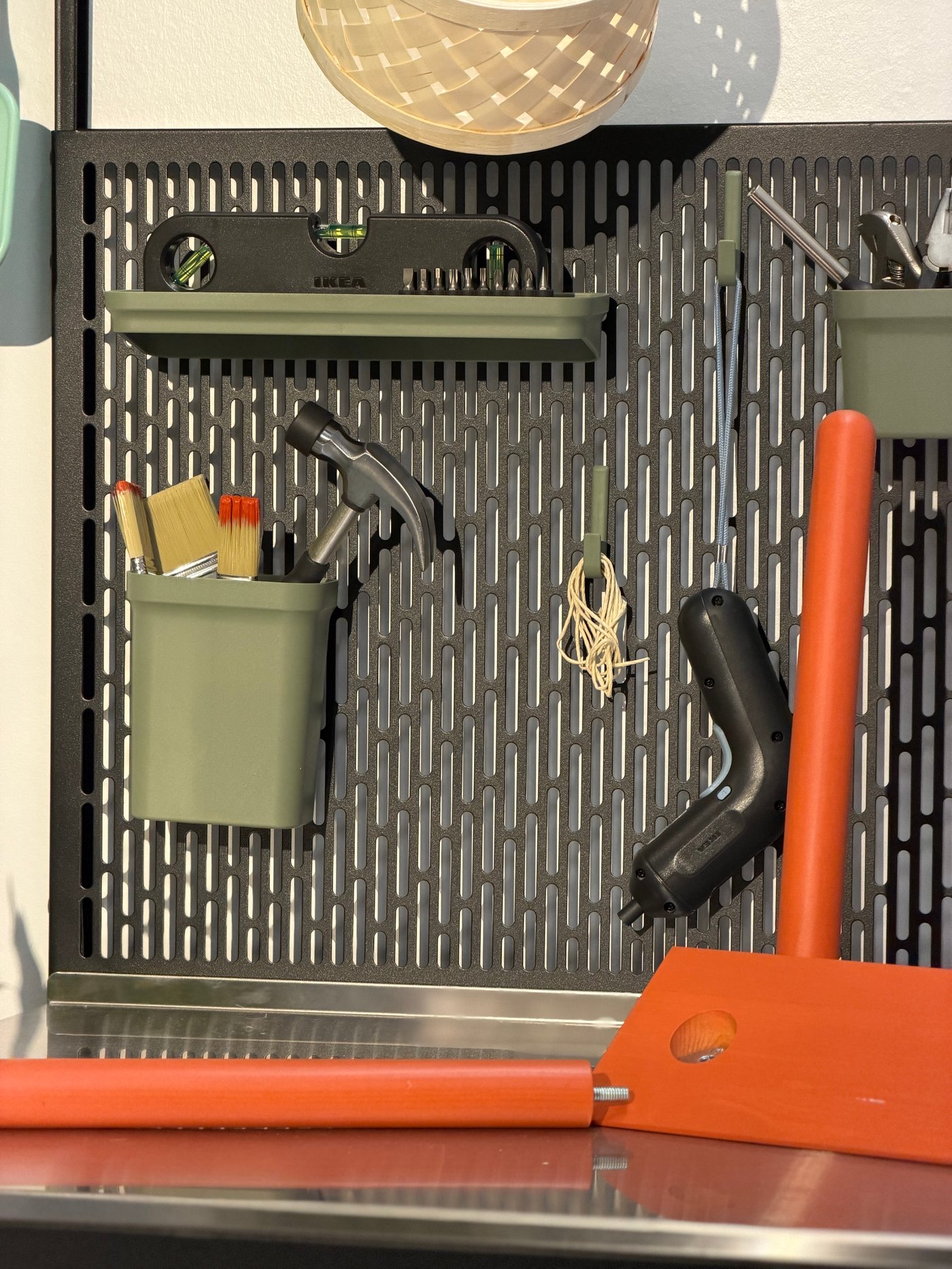 Un mur avec un panneau perforé et des outils pour bricoler