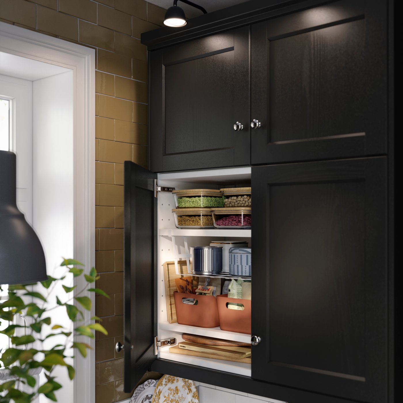 Inside a kitchen abinet featuring white PÅLYCKE clip-on basket  attached to a shelf holding organised containers & items.
