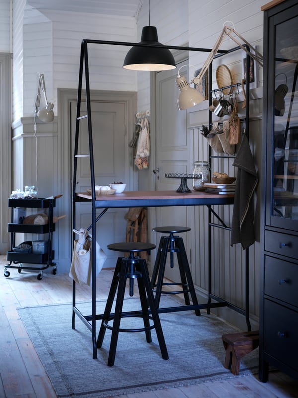 HÅVERUD table with black storage ladder is in a kitchen setting with stools and a pendant lamp hanging overhead.