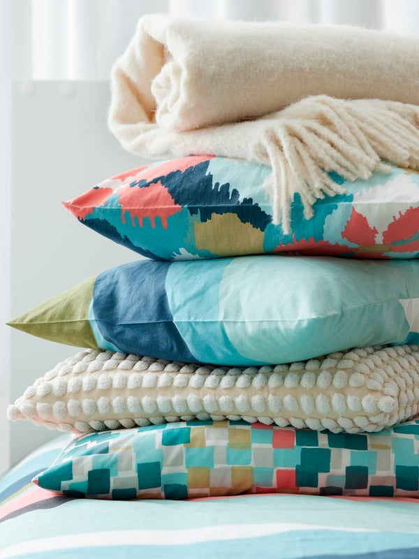 An off-white SVARTPOPPEL cushion cover