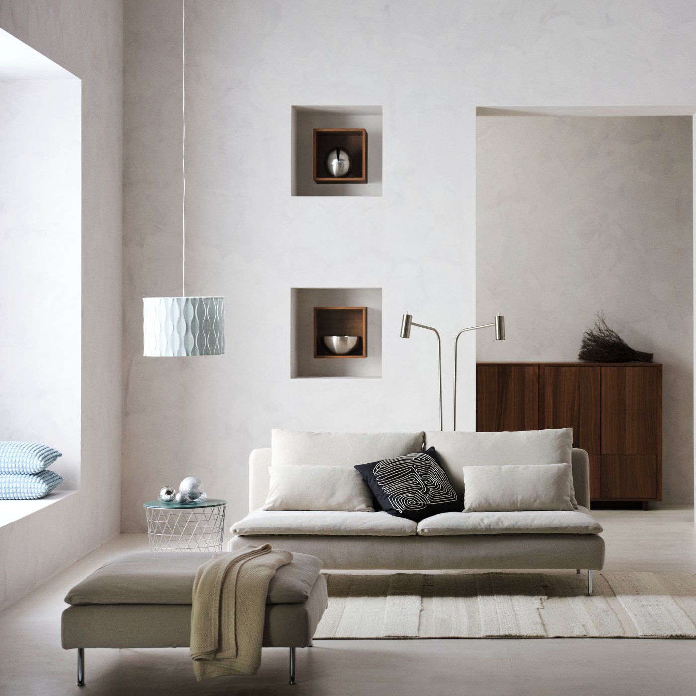 Un salon moderne spacieux avec un canapé deux places et son repose pieds SÖDERHAMN.