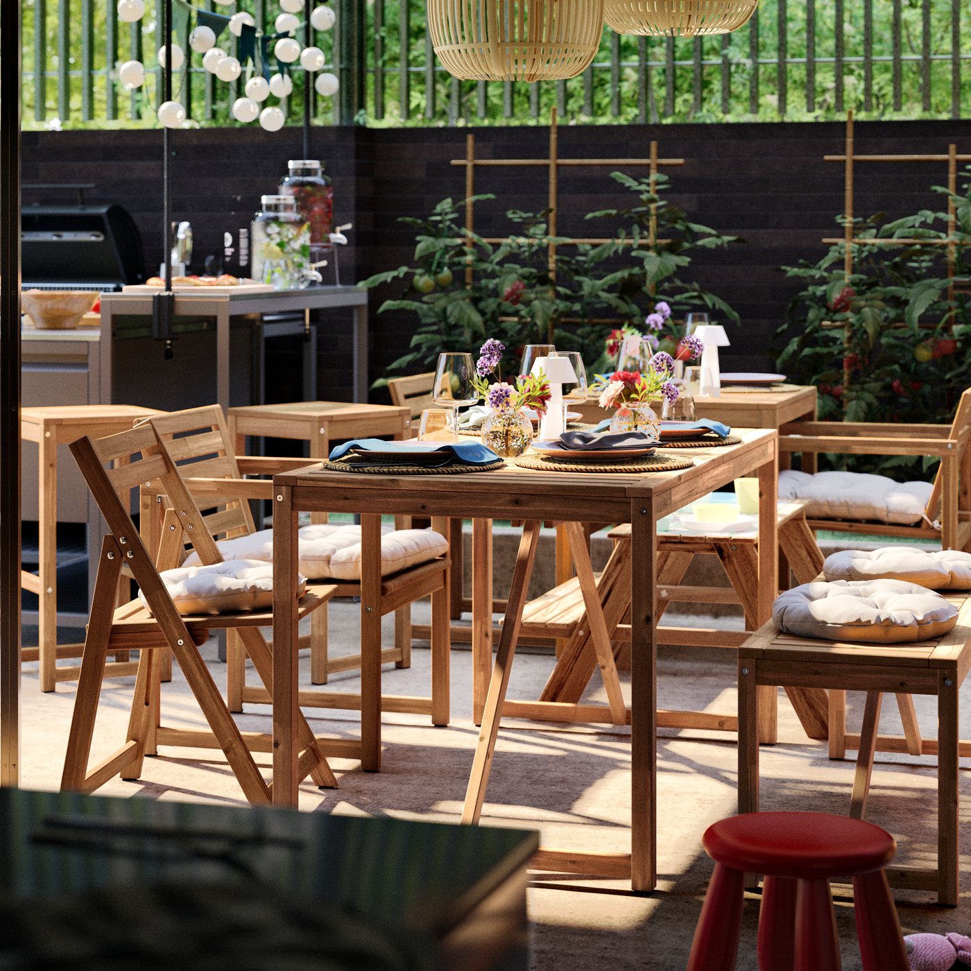 A sunny patio with a dining area furnished with mainly NÄMMARÖ outdoor furniture and a BÅTSKÄR outdoor kitchen with barbeque.