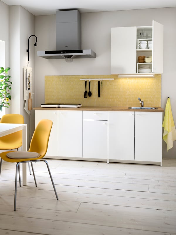 A black NÄVLINGE LED wall/clamp spotlight in the kitchen