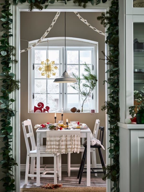 White Scandinavian traditional HAUGA table and four HAUGA chairs in small dining room with rustic Christmas decorations.