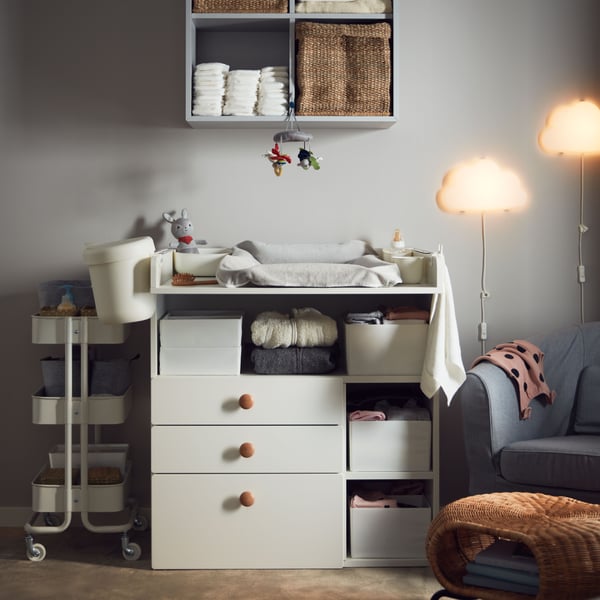 A light grey EKET wall-mounted shelving unit w 4 comp in the childrens room