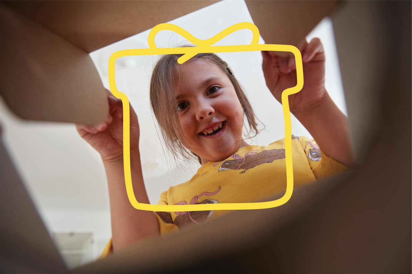 a picture of a little girl that is smiling and looking in to a box. There is a yellow present icon on the page