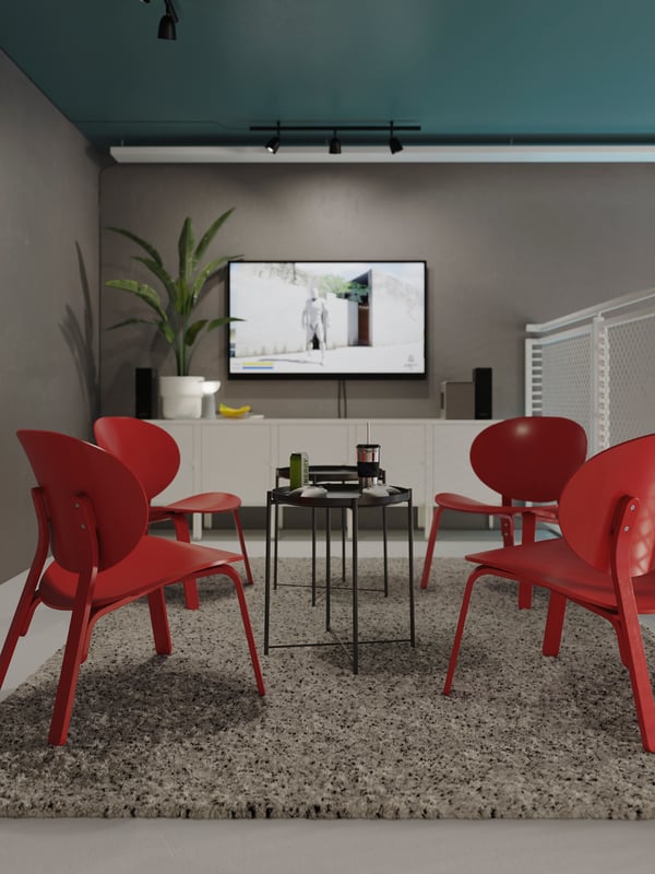 A room with grey walls and green ceiling, with four red FRÖSET easy chairs on a white VINDUM high-pile rug.